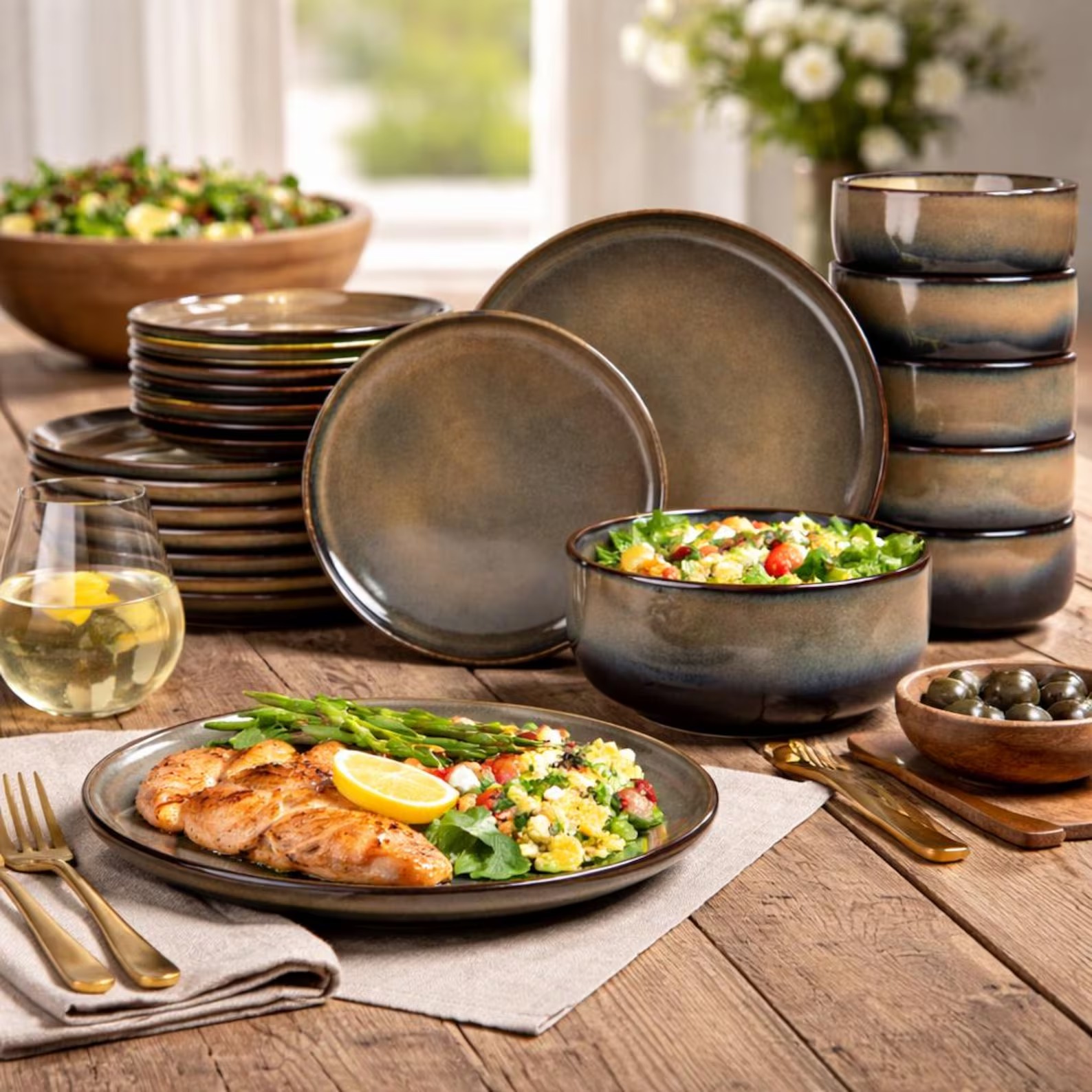 Reactive bronze-glazed plates and bowls plated with food on a rustic table